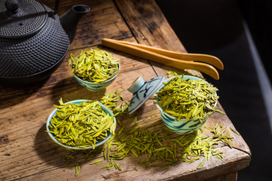 用复古茶碗碟装着的中国茗茶龙井干茶叶
