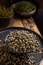 用黑色高脚碗装着的茉莉龙珠干茶叶