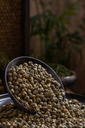装有茉莉龙珠的黑色碗倒了使茶叶倒出来了