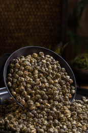 装有茉莉龙珠的黑色碗倒了使茶叶倒出来了