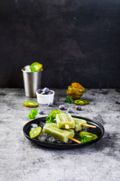 放在黑盘里的猕猴桃味的冰棍和冰块及猕猴桃