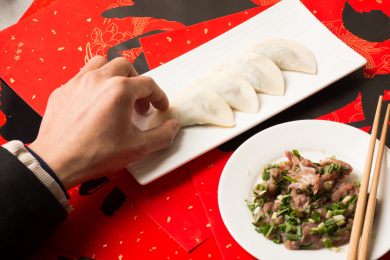 手拿放在盘子里的饺子