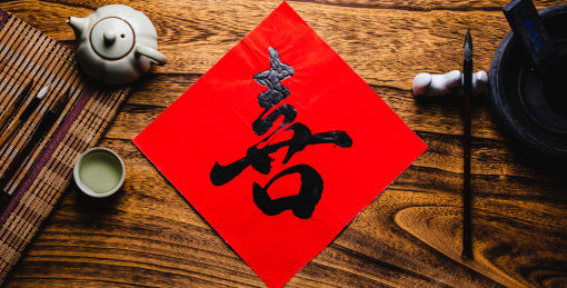 特写木桌上放着写好的喜字和笔墨纸砚