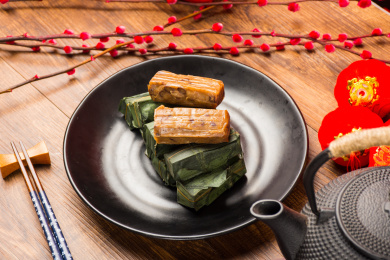 装黑盘里的竹叶糯米包饭