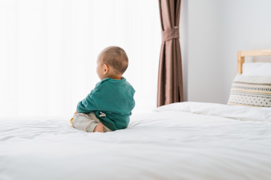 亚裔婴幼儿在床上爬行玩耍