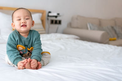 亚裔婴幼儿在床上爬行玩耍