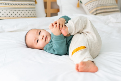 亚裔婴幼儿在床上爬行玩耍