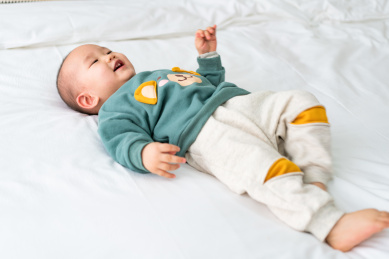 亚裔婴幼儿在床上爬行玩耍