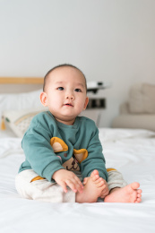 亚裔婴幼儿在床上爬行玩耍