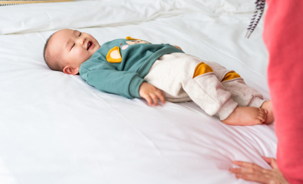 亚裔婴幼儿在床上爬行玩耍