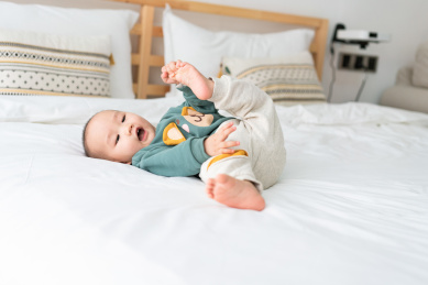 亚裔婴幼儿在床上爬行玩耍