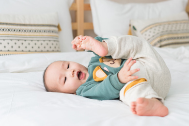 亚裔婴幼儿在床上爬行玩耍