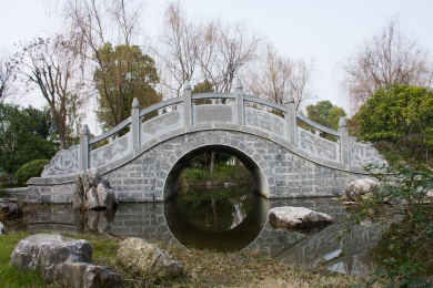 平静的水面上的传统石拱桥