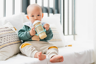 亚裔婴儿坐在飘窗上吃奶