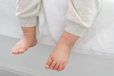 亚裔婴儿坐在飘窗上双脚特写