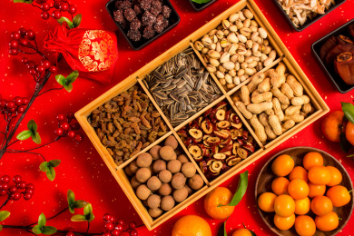 中国红背景上装在食盒中的丰富干果零食年货