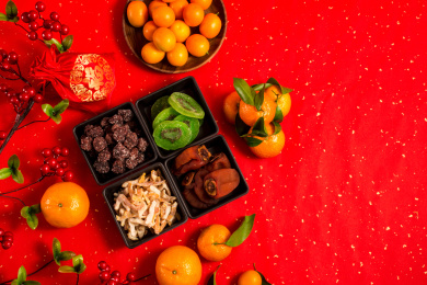 红色背景上装在黑色碟子中的各类干果零食