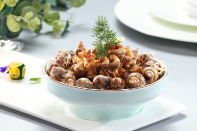 白色长瓷盘上瓷碗中的捞汁醉花螺