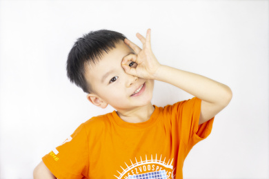 小男孩用手圈住眼睛
