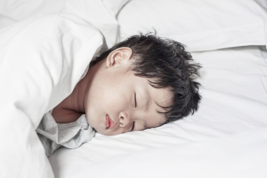 在床上熟睡的小男孩