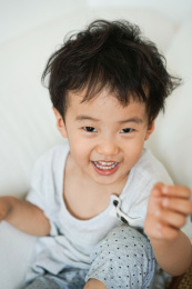 一个穿浅颜色的东方快乐男孩