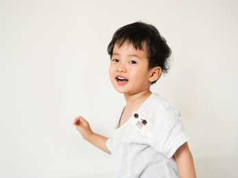 一个穿浅颜色的东方快乐男孩