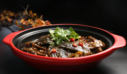 深色背景上红色砂锅里的干锅甲鱼