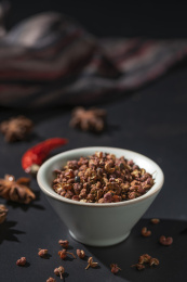 深色背景上一碗传统调料花椒特写