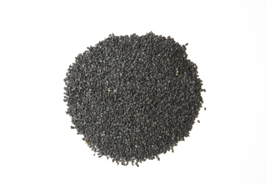 俯拍白色桌面背景上散落一把黑芝麻