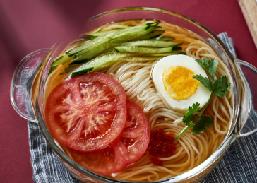 深红色背景上餐具里盛放的朝鲜冷面