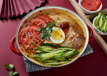 深红色背景上餐具里盛放的朝鲜冷面