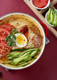 深红色背景上餐具里盛放的朝鲜冷面