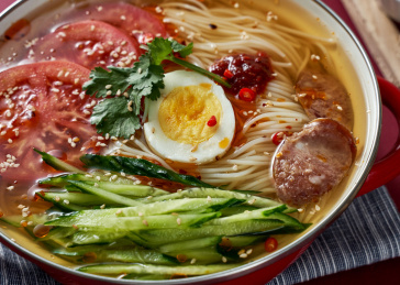 深红色背景上餐具里盛放的朝鲜冷面