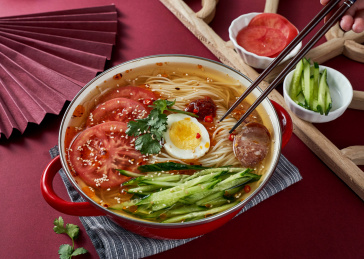 深红色背景上餐具里盛放的朝鲜冷面