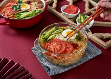 深红色背景上餐具里盛放的朝鲜冷面