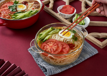 深红色背景上餐具里盛放的朝鲜冷面