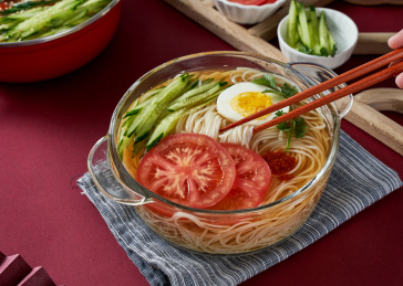 深红色背景上餐具里盛放的朝鲜冷面