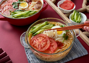 深红色背景上餐具里盛放的朝鲜冷面