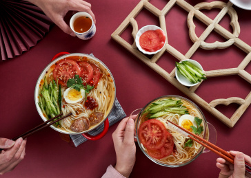 深红色背景上餐具里盛放的朝鲜冷面