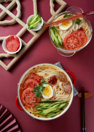 深红色背景上餐具里盛放的朝鲜冷面