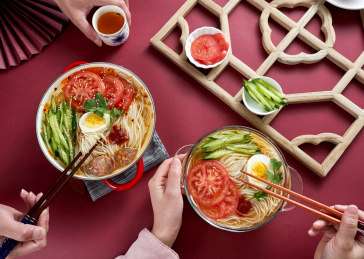 深红色背景上餐具里盛放的朝鲜冷面