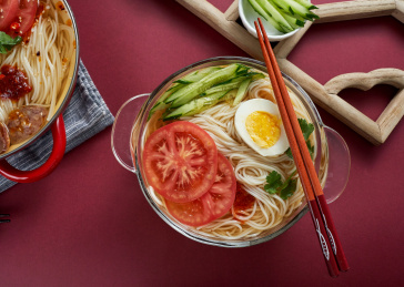 深红色背景上餐具里盛放的朝鲜冷面