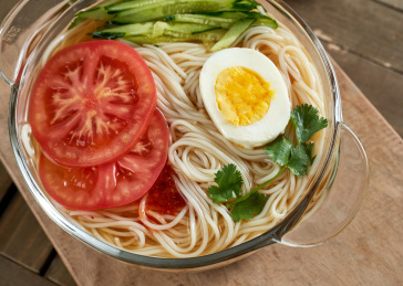 深红色背景上餐具里盛放的朝鲜冷面