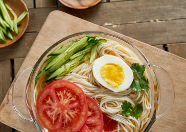 深红色背景上餐具里盛放的朝鲜冷面