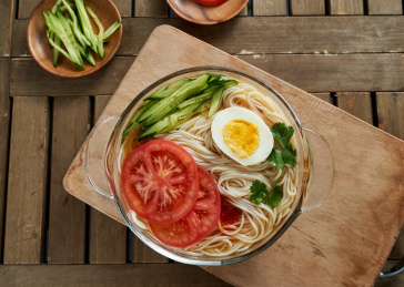 深红色背景上餐具里盛放的朝鲜冷面