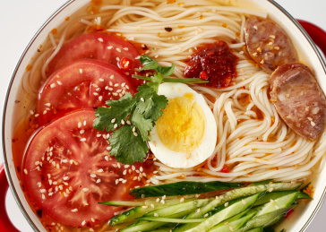 白色背景上餐具里盛放的朝鲜冷面