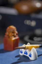 摆在木桌面上的毛笔印章砚台等文房四宝特写