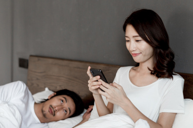 在床上坐着的年轻情侣