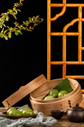 木板背景上蒸笼里的小吃青团