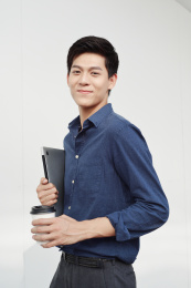 一手抱着笔记本电脑一手拿着咖啡杯商务男士